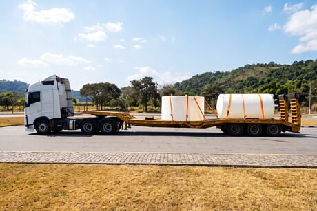Prancha estendida com dois reservatórios industriais amarrados, pronta para seguir viagem.